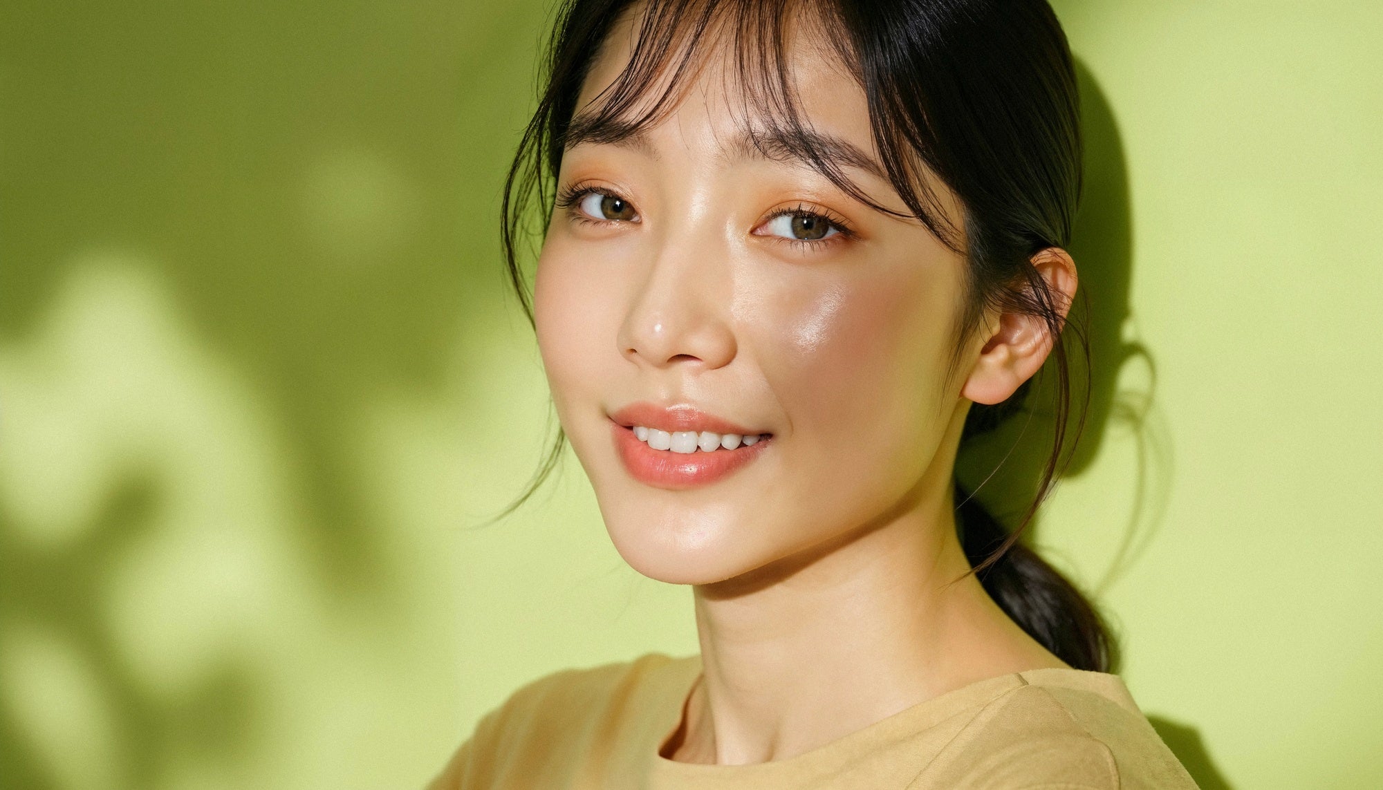 Woman with a ponytail against a green background