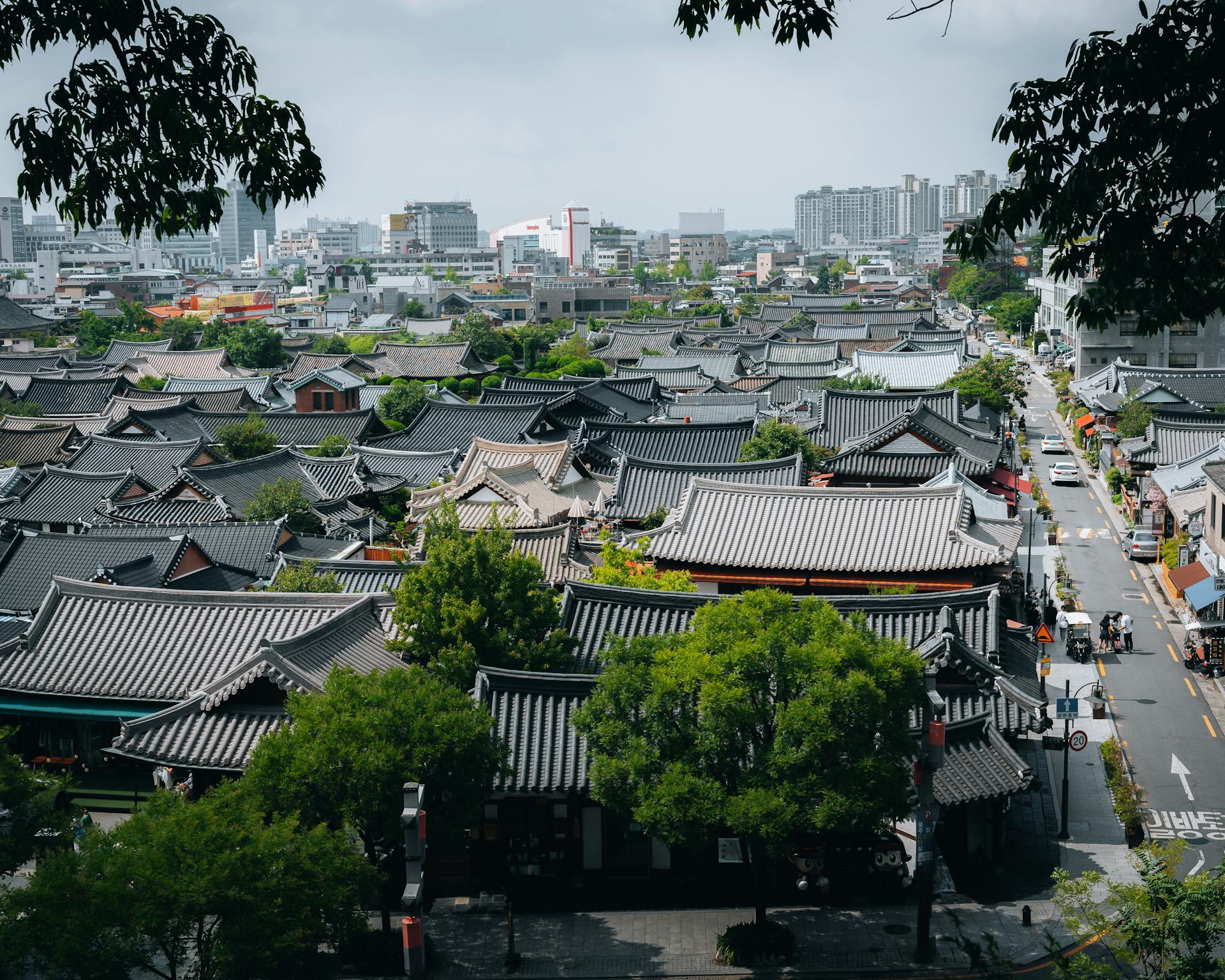 Traditional Korean architecture with modern cityscape in the background